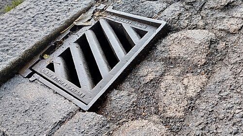 Pothole damage around street drain gully