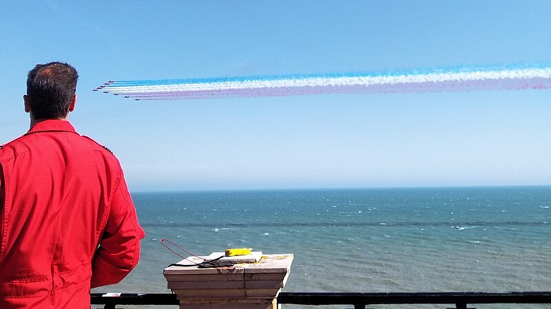 Red Arrows in flight with "Red One" commentary in foreground