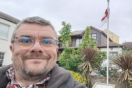 Tim Prater on Sandgate Village Green with St George Cross flag