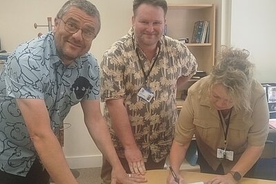 Toni Brenchley signing, and Tim Prater & Connor McConville witnessing, the deeds of purchase of 2 Grace Hill
